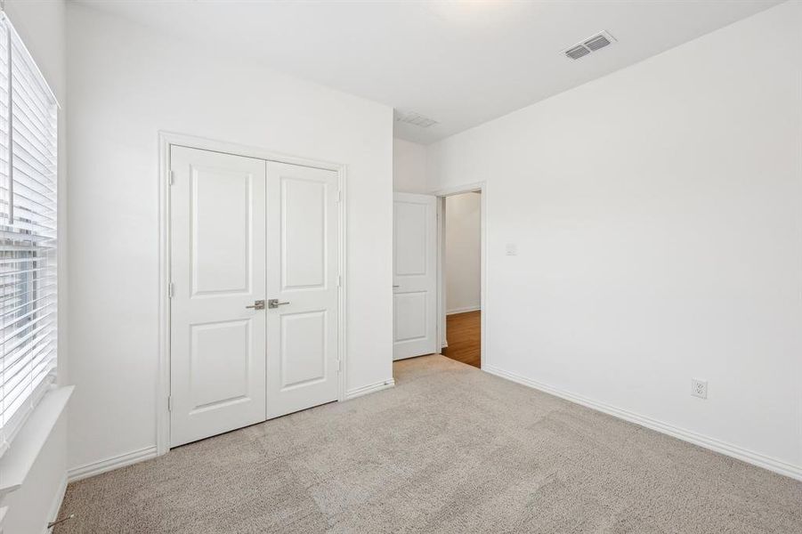 Unfurnished bedroom featuring a closet and light colored carpet