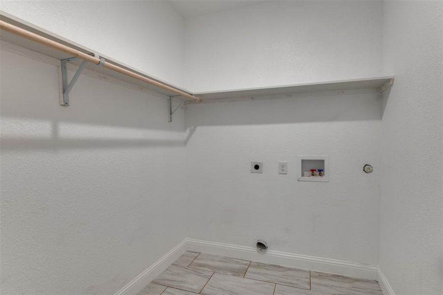 Laundry area featuring electric dryer hookup, hookup for a washing machine, and hookup for a gas dryer Laundry area featuring electric dryer hookup, hookup for a washing machine, and hookup for a gas dryer