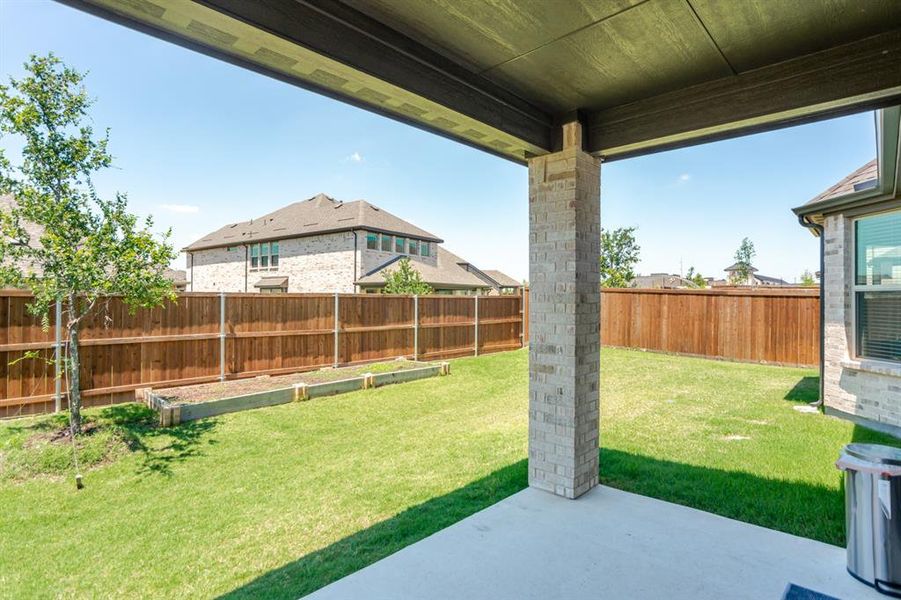 Covered patio with a concrete slab, a brick-clad support column, and a wood-finish ceiling