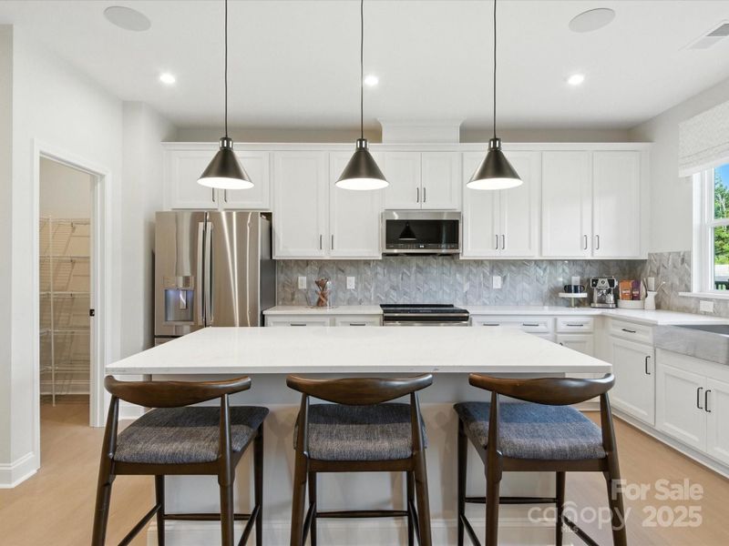 Large central island for casual dining or meal preparation. *Model Photos | Actual finishes, orientation, and structural selections may vary.