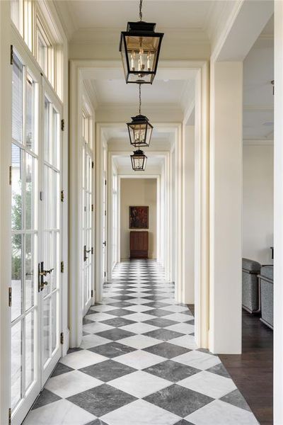 Hall with crown molding, a chandelier, and french doors Hall with crown molding, a chandelier, and french doors