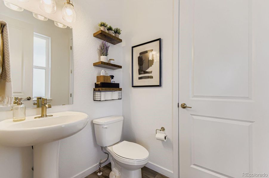 A well-appointed guest powder bath is thoughtfully positioned on the third level, offering convenience for the kitchen, dining, and living areas.