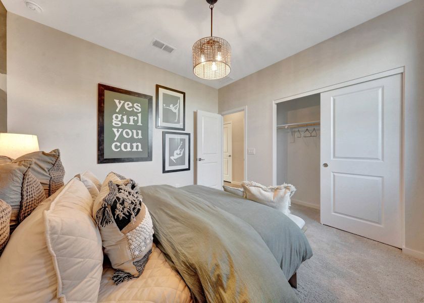 A bedroom with a bed and a chandelier.