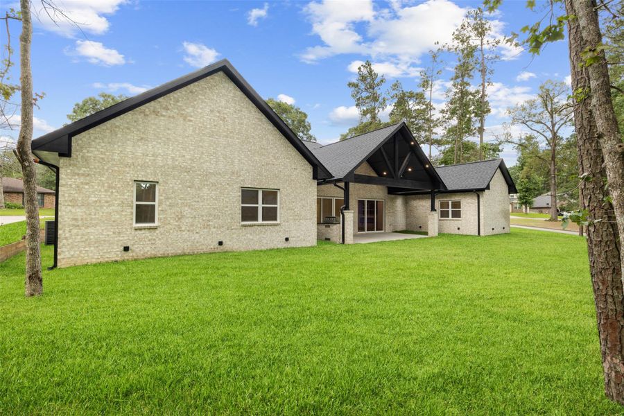 pacious backyard with covered outdoor living and outdoor kitchen.