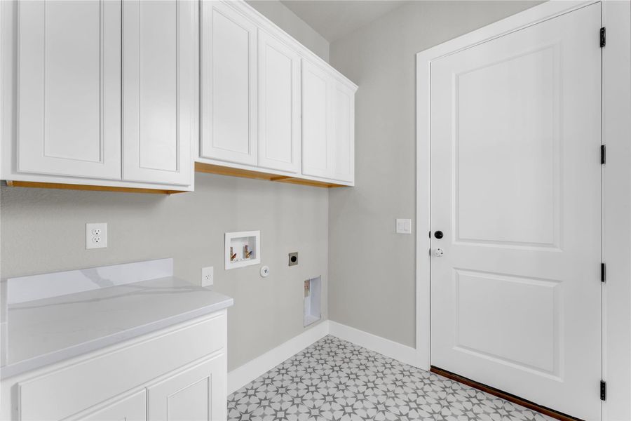 Laundry area featuring hookup for a washing machine, electric dryer hookup, cabinet space, light flooring, and gas dryer hookup
