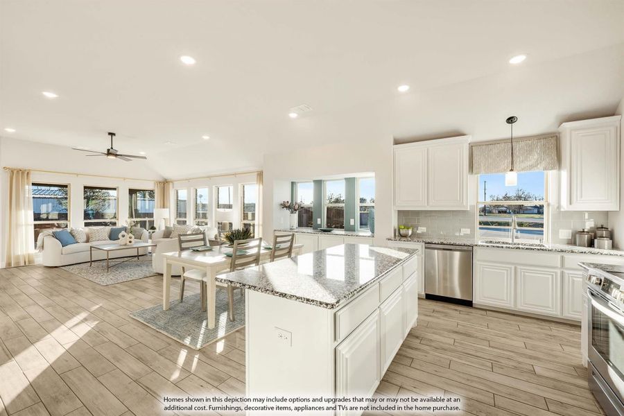 Open-concept kitchen with granite island and white cabinets, flowing into dining and living areas with wood-look floors Open-concept kitchen with granite island and white cabinets, flowing into dining and living areas with wood-look floors