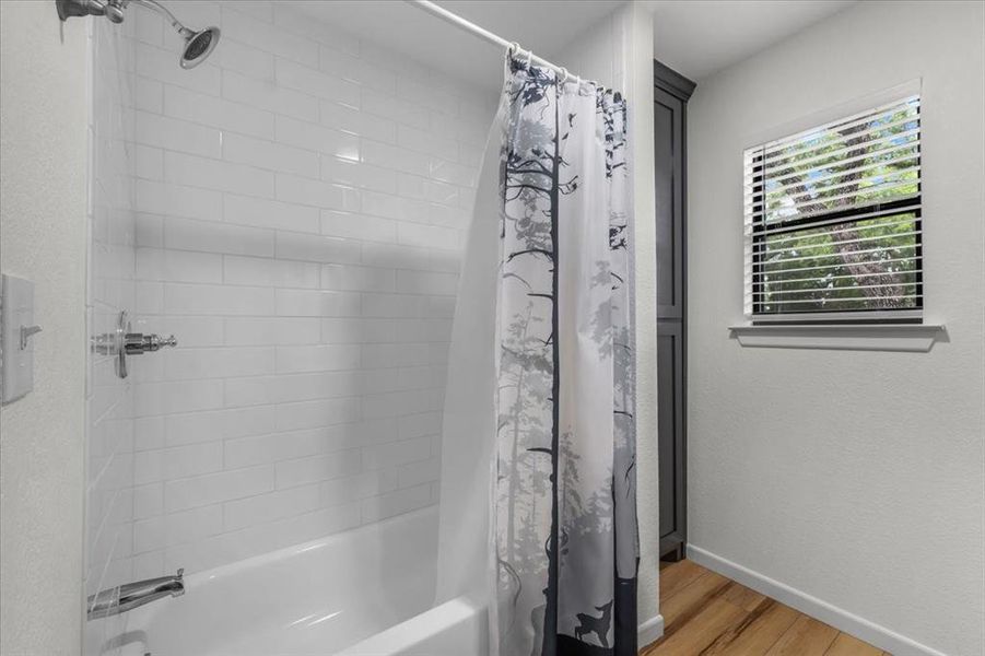 Bathtub and shower combination featuring white subway tile surround and chrome fixtures