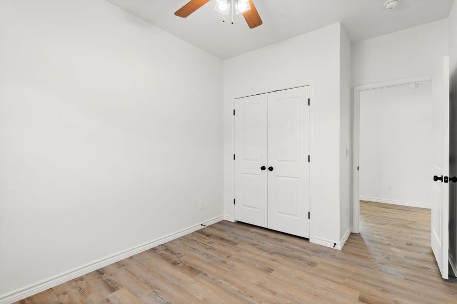 Unfurnished bedroom with a closet, light wood-style flooring, baseboards, and ceiling fan Unfurnished bedroom with a closet, light wood-style flooring, baseboards, and ceiling fan