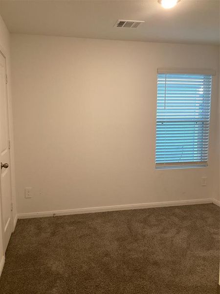 Cozy Guest Bedroom: Featuring plush carpeting, ample natural light, and a fresh neutral palette ready for your personal touch.