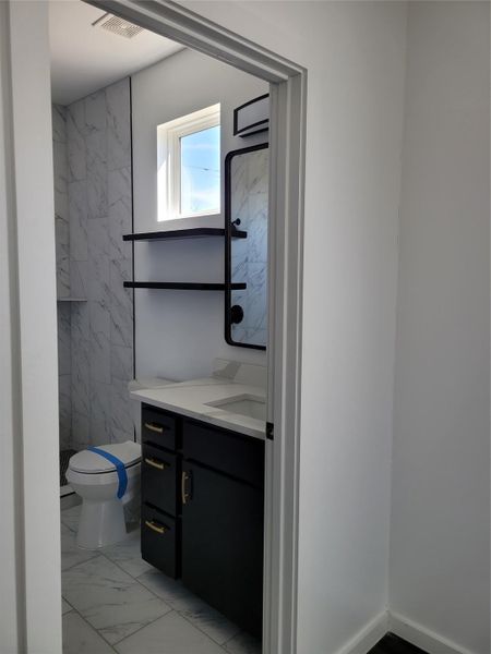 A chic vanity with sleek black cabinetry offers stylish storage within this contemporary bathroom. A chic vanity with sleek black cabinetry offers stylish storage within this contemporary bathroom.