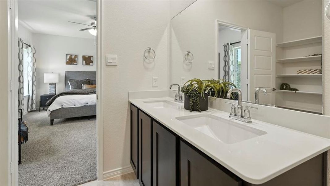 Ensuite bathroom featuring light colored carpet, double vanity, a ceiling fan, and a shower with curtain