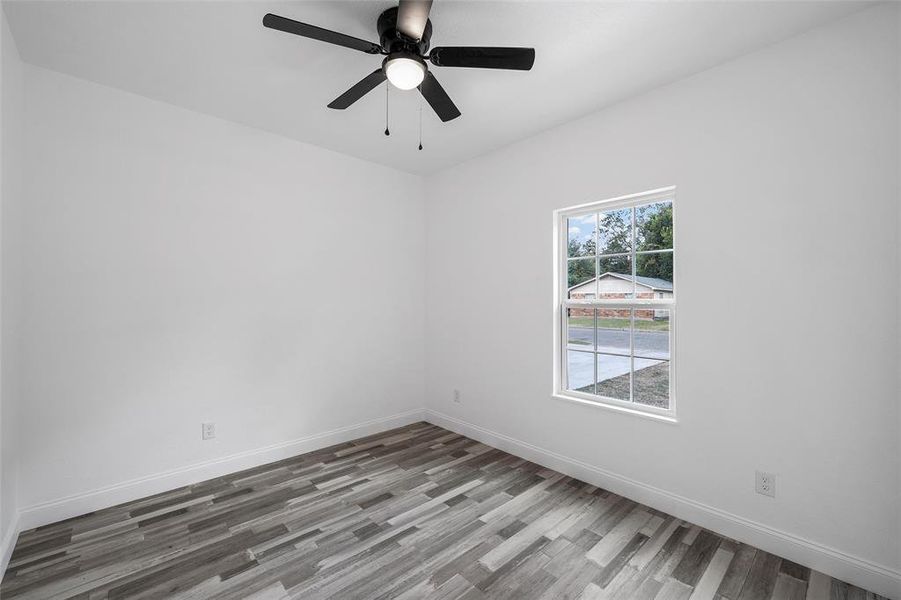Empty room with light wood-type flooring and a ceiling fan