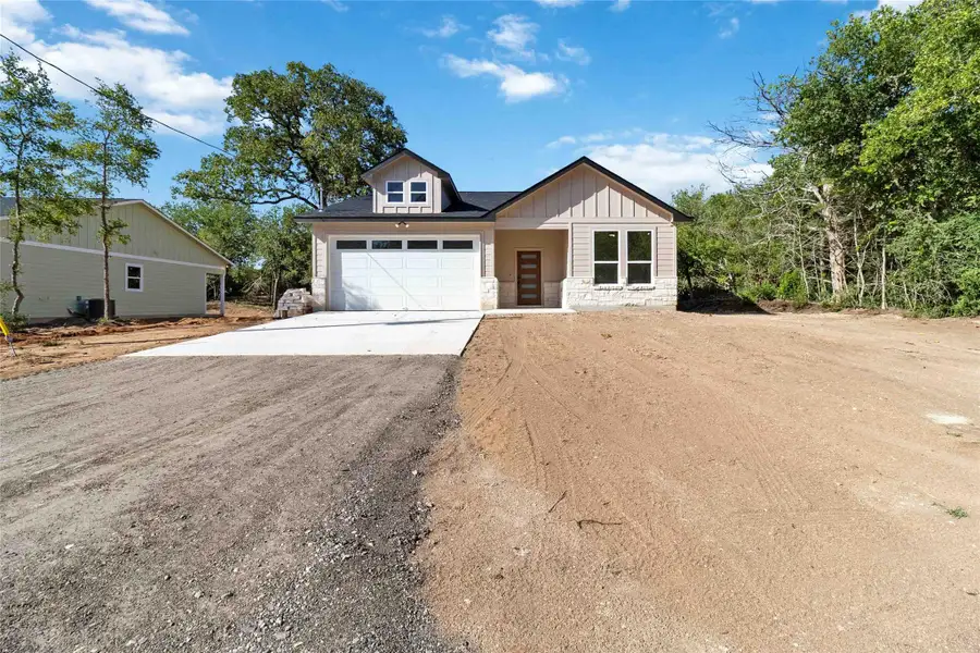 View of front of house featuring driveway, stone siding, a garage, and board and batten siding View of front of house featuring driveway, stone siding, a garage, and board and batten siding
