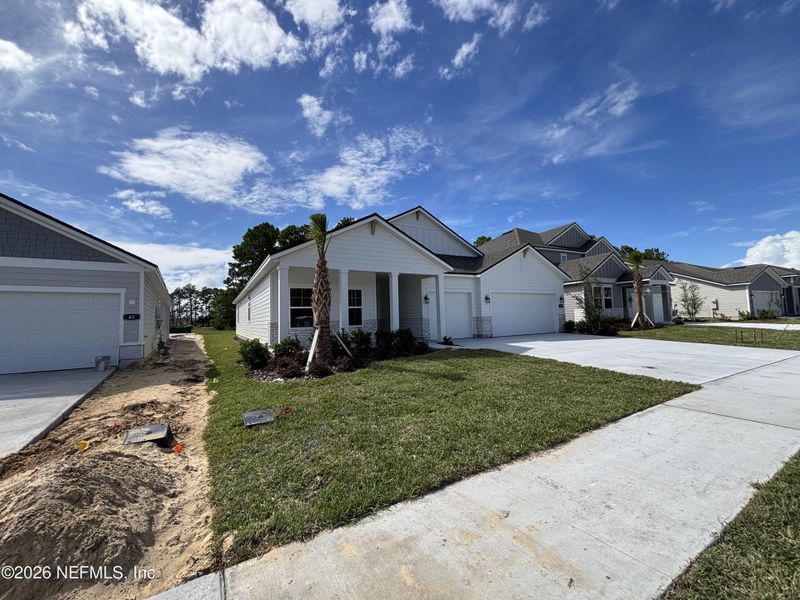 Front exterior of a new home in The Cypress Series at Reserve East, Flagler Beach, FL, highlighting curb appeal (Image 16).
