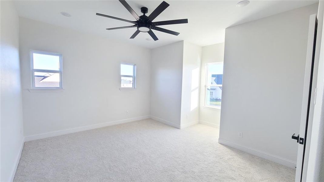 Carpeted spare room with ceiling fan