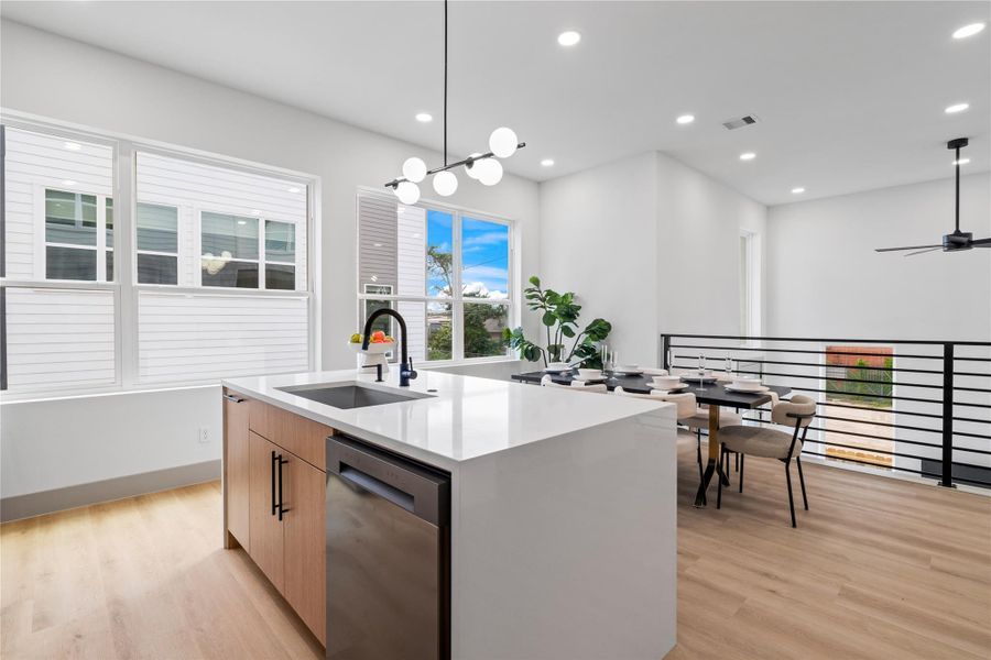 Framed by walls of windows and modern horizontal railings, this elevated kitchen and dining space invites natural light to pour in—highlighting the crisp quartz countertops, sleek matte black fixtures, and seamless indoor-outdoor flow. It's a setting designed for connection, conversation, and everyday luxury. Framed by walls of windows and modern horizontal railings, this elevated kitchen and dining space invites natural light to pour in—highlighting the crisp quartz countertops, sleek matte black fixtures, and seamless indoor-outdoor flow. It's a setting designed for connection, conversation, and everyday luxury.