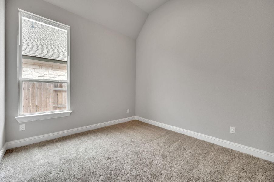 Spare room featuring carpet floors, vaulted ceiling, and baseboards Spare room featuring carpet floors, vaulted ceiling, and baseboards