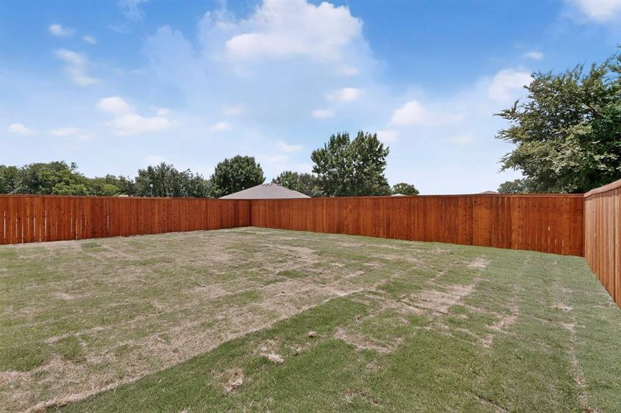 Expansive backyard featuring a new privacy fence and a level grassed area