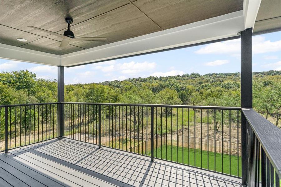Deck featuring ceiling fan and a view of trees