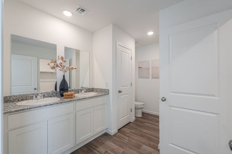 A bathroom with white cabinets.