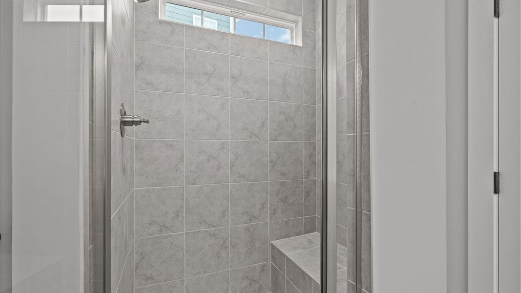 Exceptional en-suite with dual vanity and glass-enclosed tiled walk-in shower for superior everyday comfort