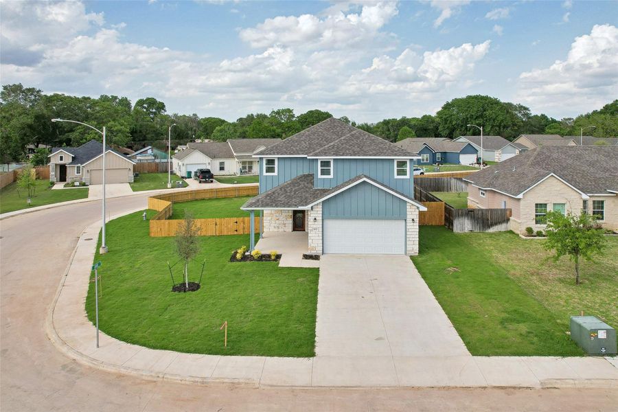 Traditional-style house featuring driveway, board and batten siding, fence, a front yard, and a residential view Traditional-style house featuring driveway, board and batten siding, fence, a front yard, and a residential view