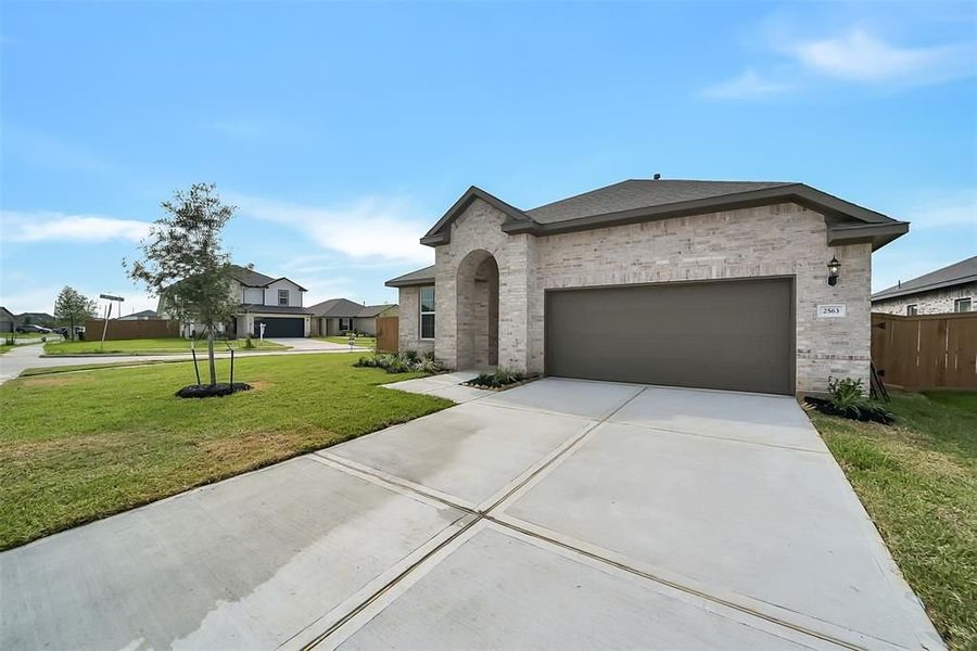 Front exterior of a new home in Sunterra, Katy, TX, highlighting curb appeal (Image 26).
