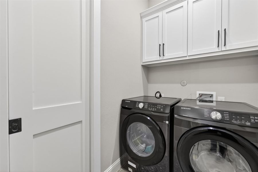 Utility room with overhead cabinets and washer/dryer connections. Utility room with overhead cabinets and washer/dryer connections.