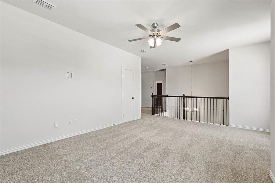 Empty room featuring light colored carpet and ceiling fan