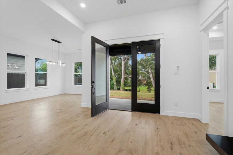 Indoor-Outdoor Harmony. Perfect for entertaining, the sunny dining alcove features a sleek designer light fixture and sits adjacent to magnificent double glass doors that open directly onto the covered back patio.