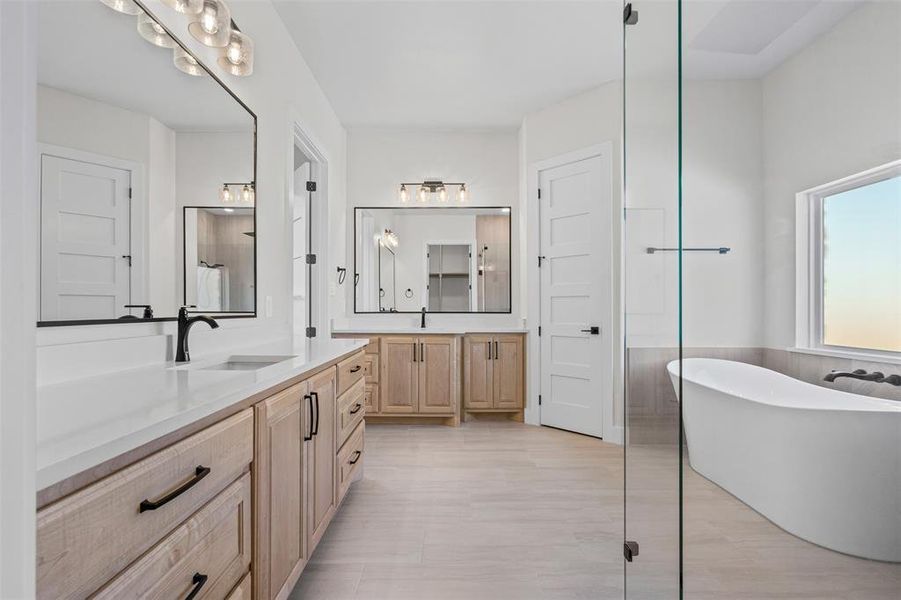 Full bathroom with a freestanding tub, two vanities, and wainscoting
