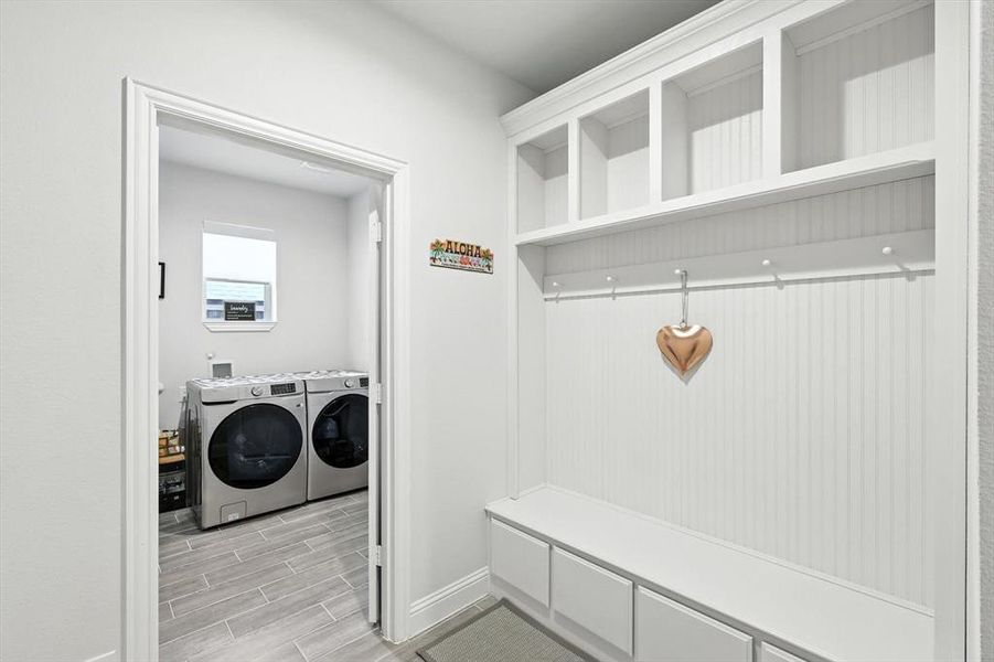 Mudroom with separate washer and dryer and wood finish floors