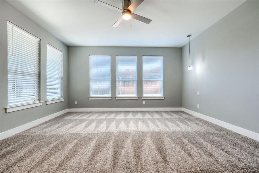 Spare room with ceiling fan and light colored carpet