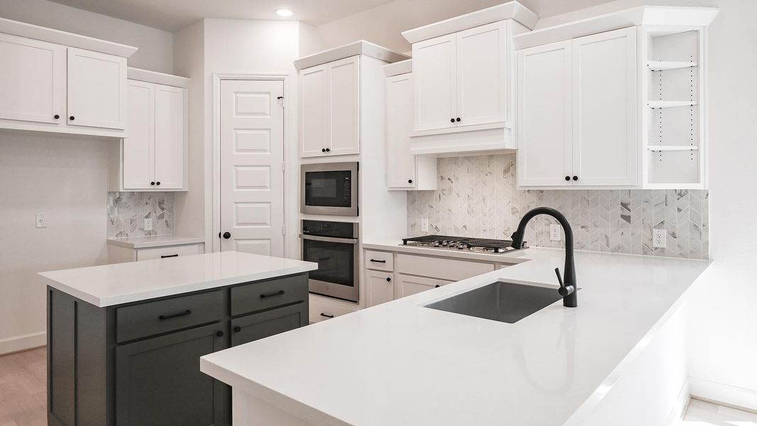 Kitchen featuring decorative backsplash, white cabinets, stainless steel appliances, open shelves, and a kitchen island Kitchen featuring decorative backsplash, white cabinets, stainless steel appliances, open shelves, and a kitchen island