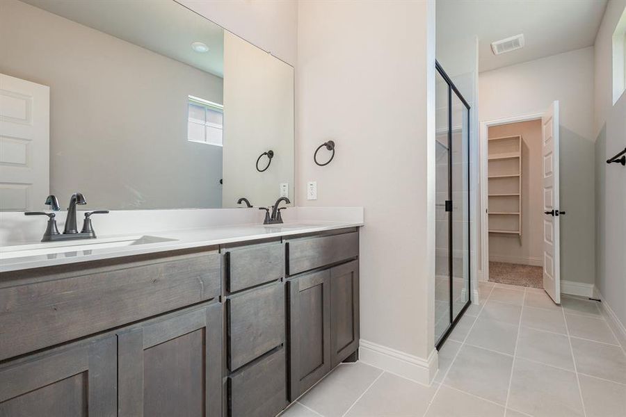 Bathroom with vanity, tile patterned floors, and walk in shower