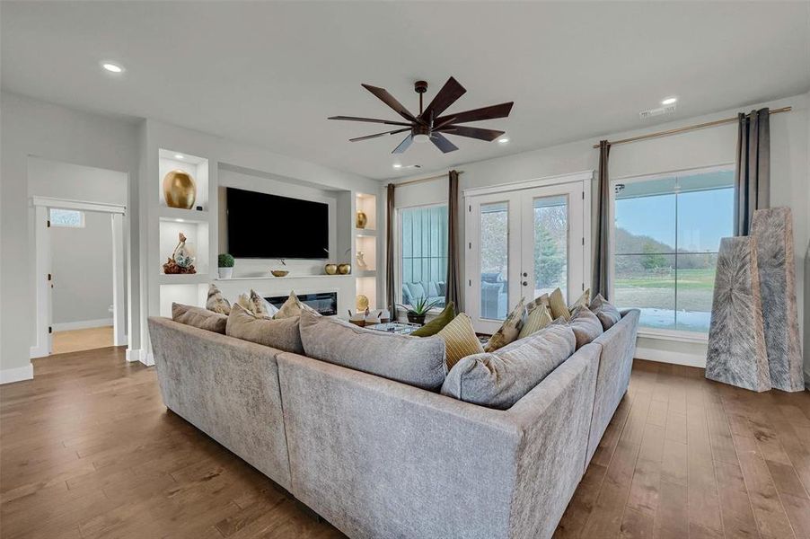 Living room with hardwood / wood-style flooring, french doors, and ceiling fan