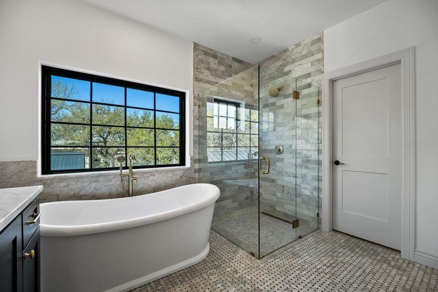 Bathroom with a stall shower, a freestanding tub, and vanity