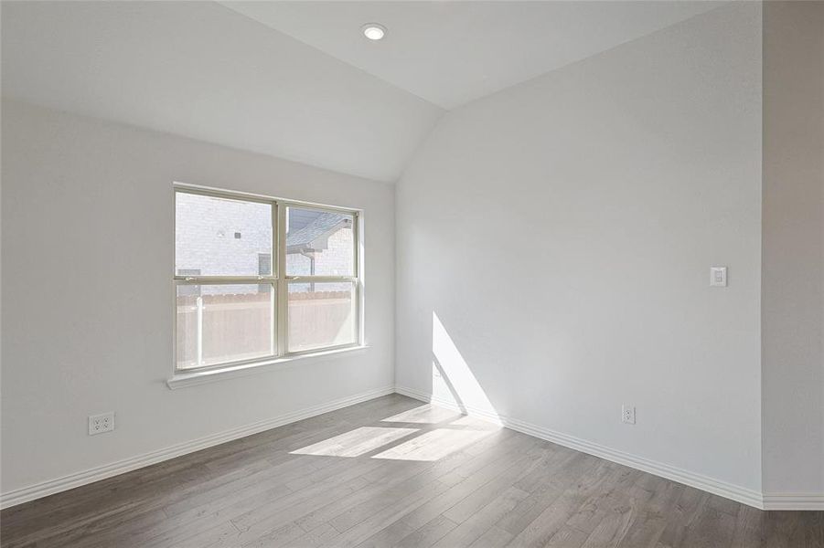 Unfurnished room with lofted ceiling and light wood-type flooring