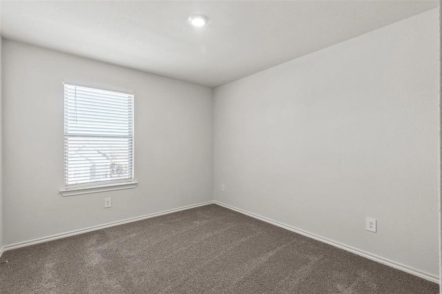 Neutral-toned room with white walls, a single window featuring horizontal blinds, and recessed ceiling lighting
