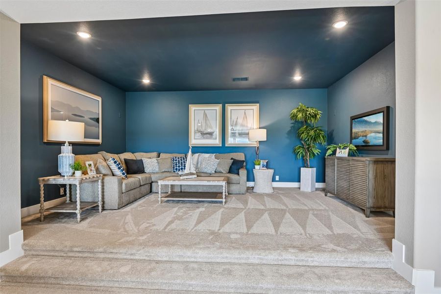 Sunken living room with blue accent walls, gray sectional sofa, and patterned carpet Sunken living room with blue accent walls, gray sectional sofa, and patterned carpet