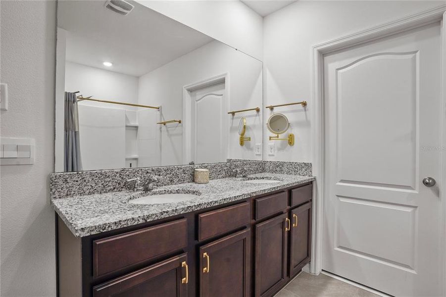 Primary Bathroom with granite and wood cabinets Primary Bathroom with granite and wood cabinets