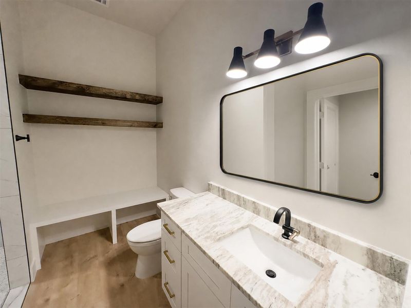Rich wood shelving and stone countertops add warm character to this modern bathroom. Rich wood shelving and stone countertops add warm character to this modern bathroom.