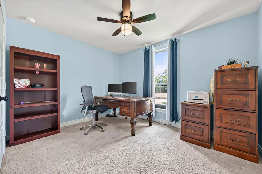 This is a spacious, light-filled, front-facing bedroom that is currently staged and utilized as a professional home office, showcasing the property's incredible versatility for remote work or a dedicated study area. This is a spacious, light-filled, front-facing bedroom that is currently staged and utilized as a professional home office, showcasing the property's incredible versatility for remote work or a dedicated study area.