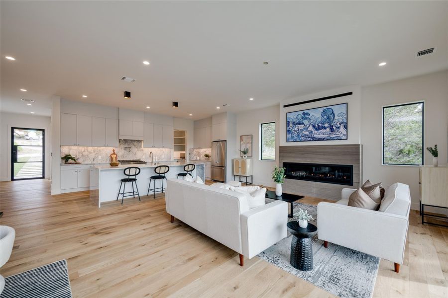 Additional living space featuring vaulted ceiling with beams, a wall mounted AC, and light wood-type flooring