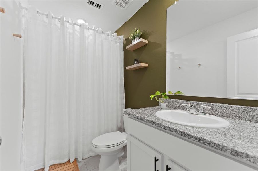 Full bath featuring curtained shower, vanity, and light tile patterned flooring