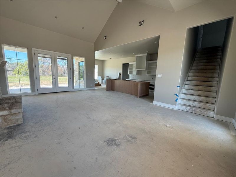 Unfurnished living room with a high ceiling and french doors
