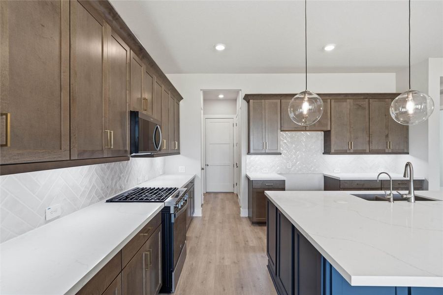 Welcome to the heart of the home, a modern, highly functional kitchen that perfectly balances style and utility. Quartz countertops, complemented by a stylish backsplash, shaker-style cabinets provide ample storage, and the Whirlpool stainless steel appliances are all features of this beautiful kitchen!