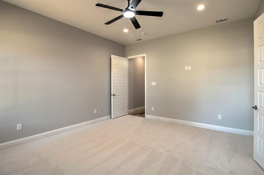 Unfurnished bedroom featuring light carpet and ceiling fan