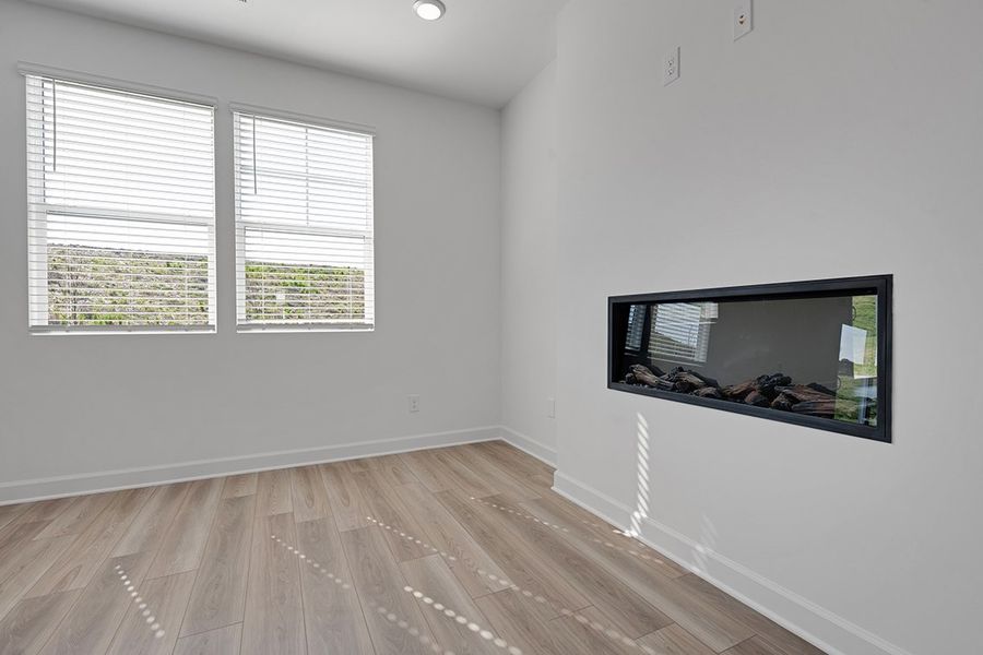 A room with a tv and a wood floor.