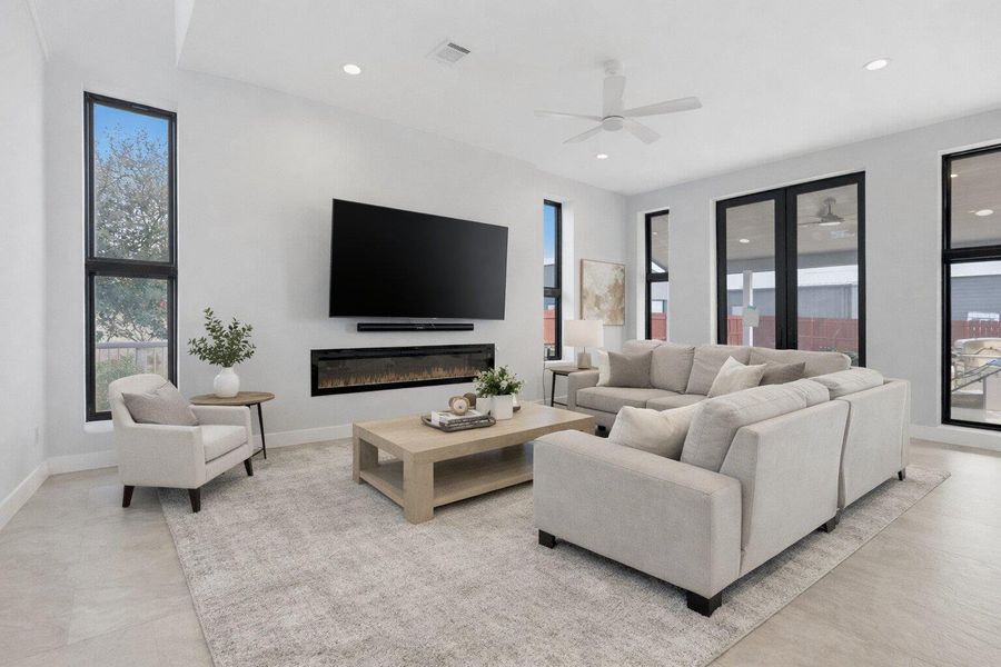 Living area with a glass covered fireplace, ceiling fan, and recessed lighting